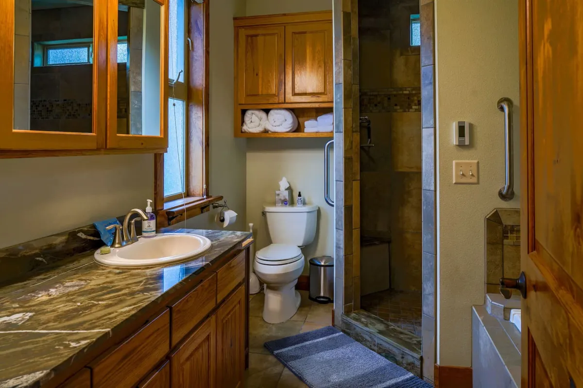 A spa-style bathroom complete with a modern vanity, spacious shower area, and warm wood cabinetry. The room is well-lit, offering a tranquil and refreshing environment for self-care.